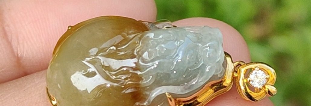 a hand holding a jade pendant